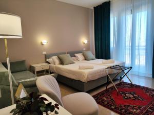 ラヴェンナにあるArtemis Roomsのベッドとリビングルームのある寝室