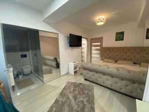 a bedroom with a large bed and a bathroom at Laura's Residence Luxury in Craiova