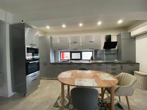 クラヨーヴァにあるLaura's Residence Luxuryのキッチン(木製テーブル、いくつかの椅子付)