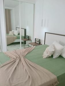 a bedroom with two beds and a large mirror at Apartamento Cidade in Mindelo