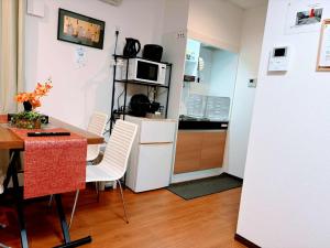 a small kitchen with a table and a refrigerator at Anabelle Residence Japan in Kawagoe