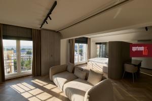 a bedroom with a couch and a bed and windows at Appartamento N in Iaşi