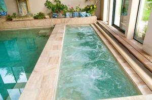 an infinity pool in a house with green water at Luxurious Mountain Retreat with Pool in Mound City