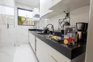 a kitchen with white walls and a black counter top at Studio Praia do jardim 1 208B in Angra dos Reis