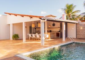 a house with a swimming pool next to a house at Kite Oasis Parajuru Villa Palmeira in Parajuru