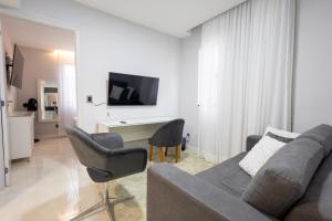 a living room with a couch and chairs and a tv at Studio Praia do jardim 1 208B in Angra dos Reis