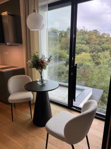 a room with a table and chairs and a window at Tiny Vanguard- Cosy flat with free luxe wellness in Prague