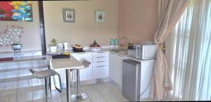 a small kitchen with a table and a refrigerator at Gorge View. in Mbabane