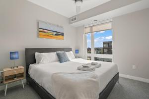 een witte slaapkamer met een groot bed en een raam bij CozySuites Marquee in Minneapolis +83 foto's