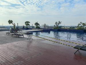 a large pool of water with benches and tables at Pollux Meisterstadt Batam Centre Sea View Tower A2 Studio by GoldenSleep in Bagam