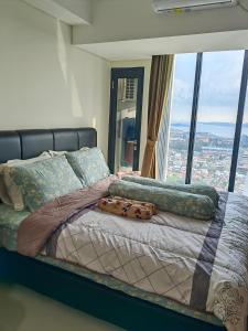 a bed in a room with a large window at Pollux Meisterstadt Batam Centre Sea View Tower A2 Studio by GoldenSleep in Bagam