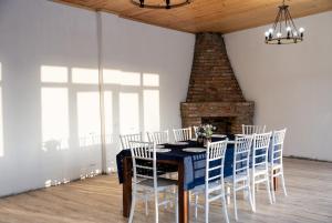 a dining room with a blue table and white chairs at Villa Mukhrani in Mukhrani