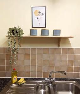 a kitchen counter with a sink and a shelf at Modern 2-Bed in Ipswich - Free Parking & Fast WiFi in Bramford
