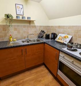 a kitchen with a sink and a stove at Modern 2-Bed in Ipswich - Free Parking & Fast WiFi in Bramford +3 photos