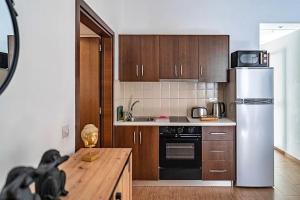 una cucina con mobili in legno e un frigorifero bianco di Cozy house city center in Limassol a Limassol Altre 21 foto