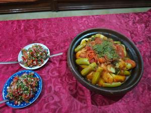 a table topped with a pot of food and a bowl of rice at Gîte akioud mazik in Imlil