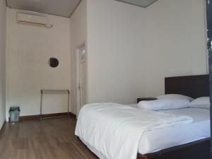 a bedroom with a large bed with white sheets at Pandava House Lombok in Lombok International Airport
