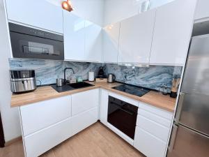 a kitchen with white cabinets and a sink at HDFM Collection - Bungalow Playa del Inglés in Playa del Ingles