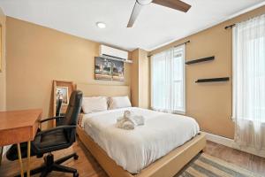 una camera da letto con scrivania e un letto con un orsacchiotto. di Charming Home in Vibrant Philadelphia a Philadelphia