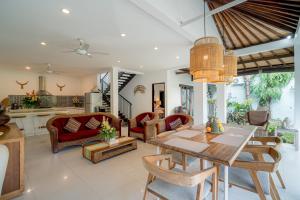 uma sala de jantar e sala de estar com mesa e cadeiras em Sari Temuku Villa em Seminyak