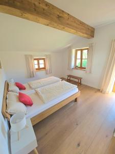 a bedroom with a large bed with red pillows at Idyllisches Ferienhaus in Kreuth am Tegernsee, ruhig & mit Bergblick in Kreuth