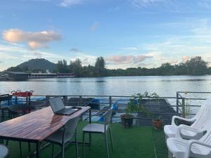 a laptop sitting on a table on the deck of a boat at Riverside Hostel Phuket in Phuket