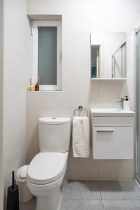 Un baño blanco con inodoro y lavabo. en Ocean Blue Onyx, en Marsaskala