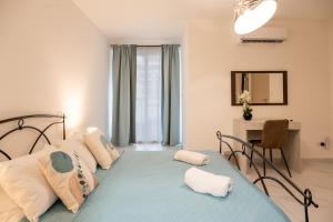 Un dormitorio con una cama, un escritorio y un espejo. en Ocean Blue Onyx, en Marsaskala