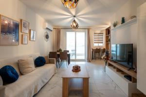 Una sala de estar con un sofá y un televisor. en Ocean Blue Onyx, en Marsaskala