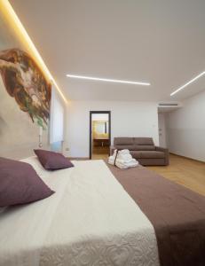 a large bed in a room with a couch at Palazzo Fiorentini Charme Hotel in Cariati +69 photos