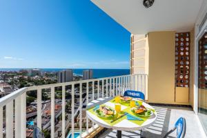 a balcony with a table and plates of food on it at Beach apartment in Las Americas in Arona