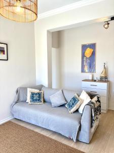 a living room with a blue couch with pillows at Aegina Heights in Aegina Town