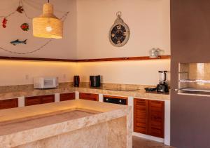 a kitchen with a counter and a clock on the wall at Kite Oasis Parajuru Villa Palmeira in Parajuru