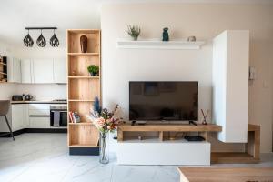 a living room with a television and a table at Ocean Blue Onyx in Marsaskala