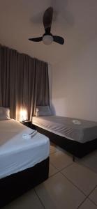 Cette chambre dispose de 2 lits et d'un ventilateur de plafond. dans l'établissement Apartamento Confortavel 2 quartos ao lado Shopping, à Uberlândia