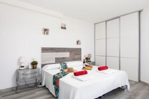 a white bedroom with two beds with red pillows at Beach apartment in Las Americas in Arona +29 photos
