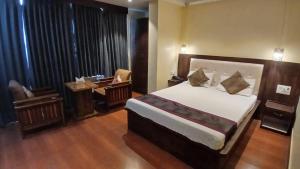 NaugachiaにあるFood Plaza Hotel Shreyash Innの部屋にベッドと机がある寝室
