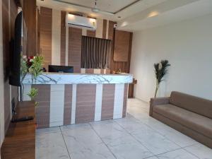 a lobby with a bar with a couch in it at Hotel Asiana Randheja Gandhinagar in Gandhinagar