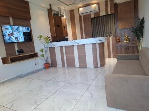 a living room with a tv and a couch at Hotel Asiana Randheja Gandhinagar in Gandhinagar