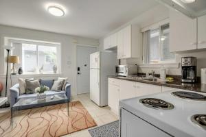 eine Küche mit weißen Schränken und einer blauen Couch in der Unterkunft Luxury 1-Bedroom Suite in Vancouver in Vancouver
