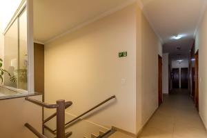 um corredor num edifício com um sinal na parede em Hotel Maria Luiza em Jundiaí