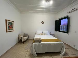 a bedroom with a large bed and a window at Suites Matriz Centro Histórico in Paraty