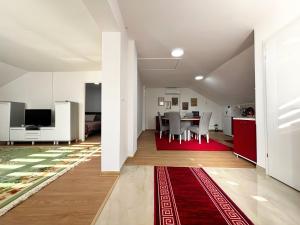 a living room with a table and a red rug at Sanlej Apartman in Tuzla