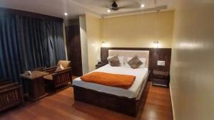 NaugachiaにあるFood Plaza Hotel Shreyash Innのベッドと机と窓のある寝室