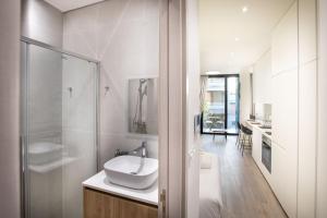 Un baño blanco con lavabo y ducha. en Irinis 150 Urban Luxury Studios, en Limassol 18 fotos más