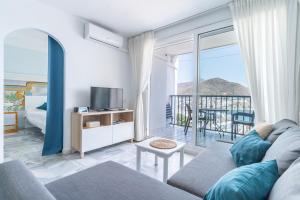a living room with a couch and a tv and a balcony at Bahía Vista in San José