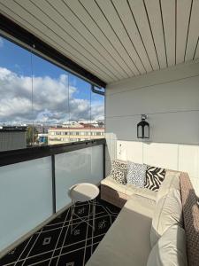 a balcony with a couch and a chair and windows at North Saga Luxury Apartment in Rovaniemi