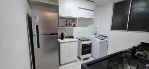 Il comprend une petite cuisine équipée d'un réfrigérateur et d'une cuisinière. dans l'établissement Apartamento Confortavel 2 quartos ao lado Shopping, à Uberlândia