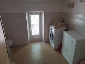 een wasruimte met een wasmachine en een raam bij Appartamento con vista sul Golfo in Lerici