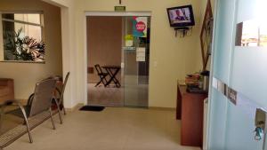 a hallway with a door and a table and chairs at Hotel Maria Luiza in Jundiaí